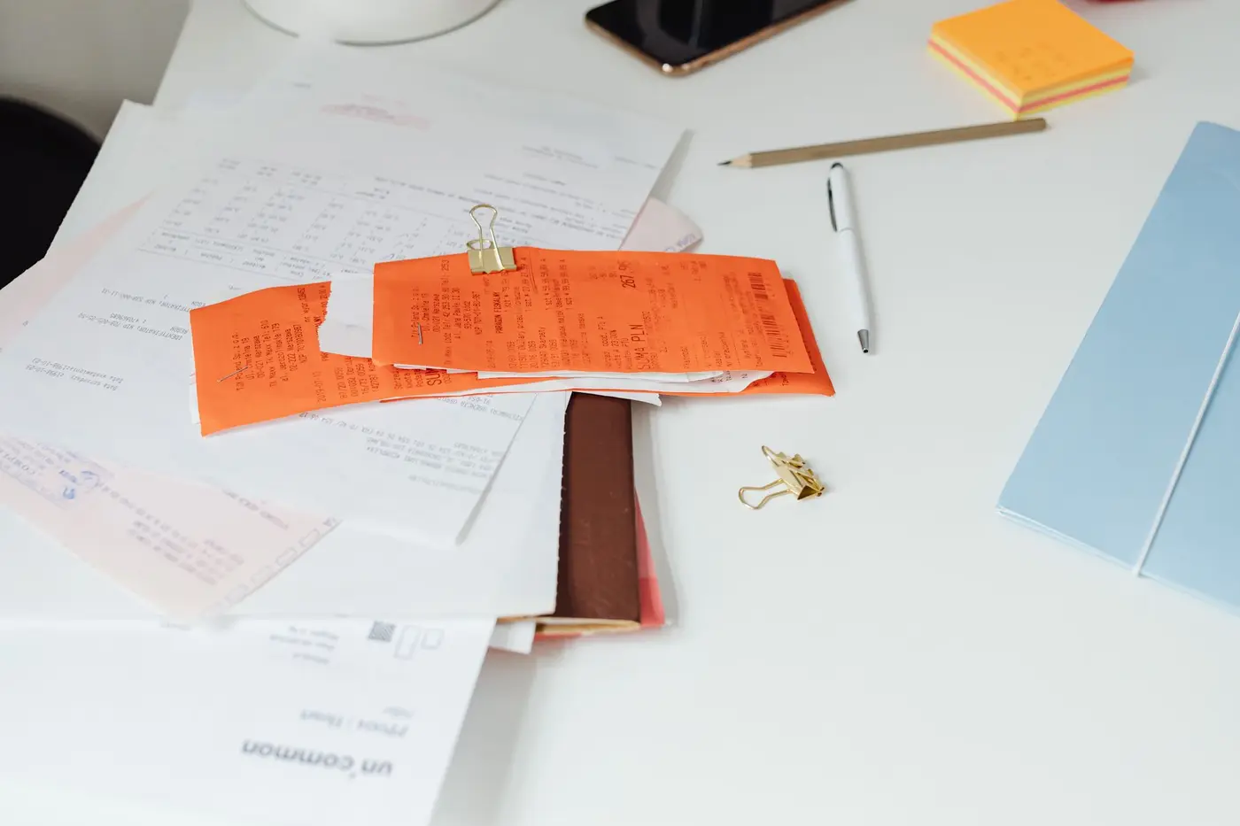 Receipts, statements and printed forms clipped together on a working desk
